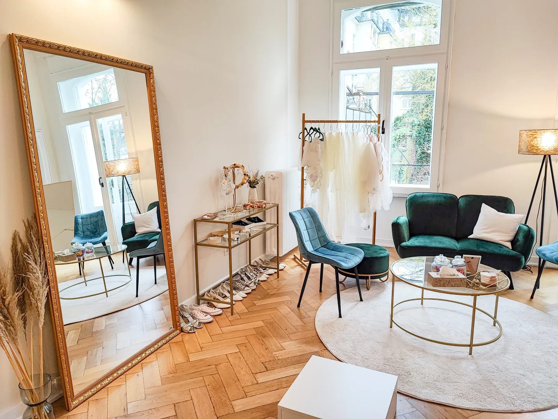 Anproberaum mit grünem Sofa und goldenem Spiegel in der Brautpoesie-Altbauvilla