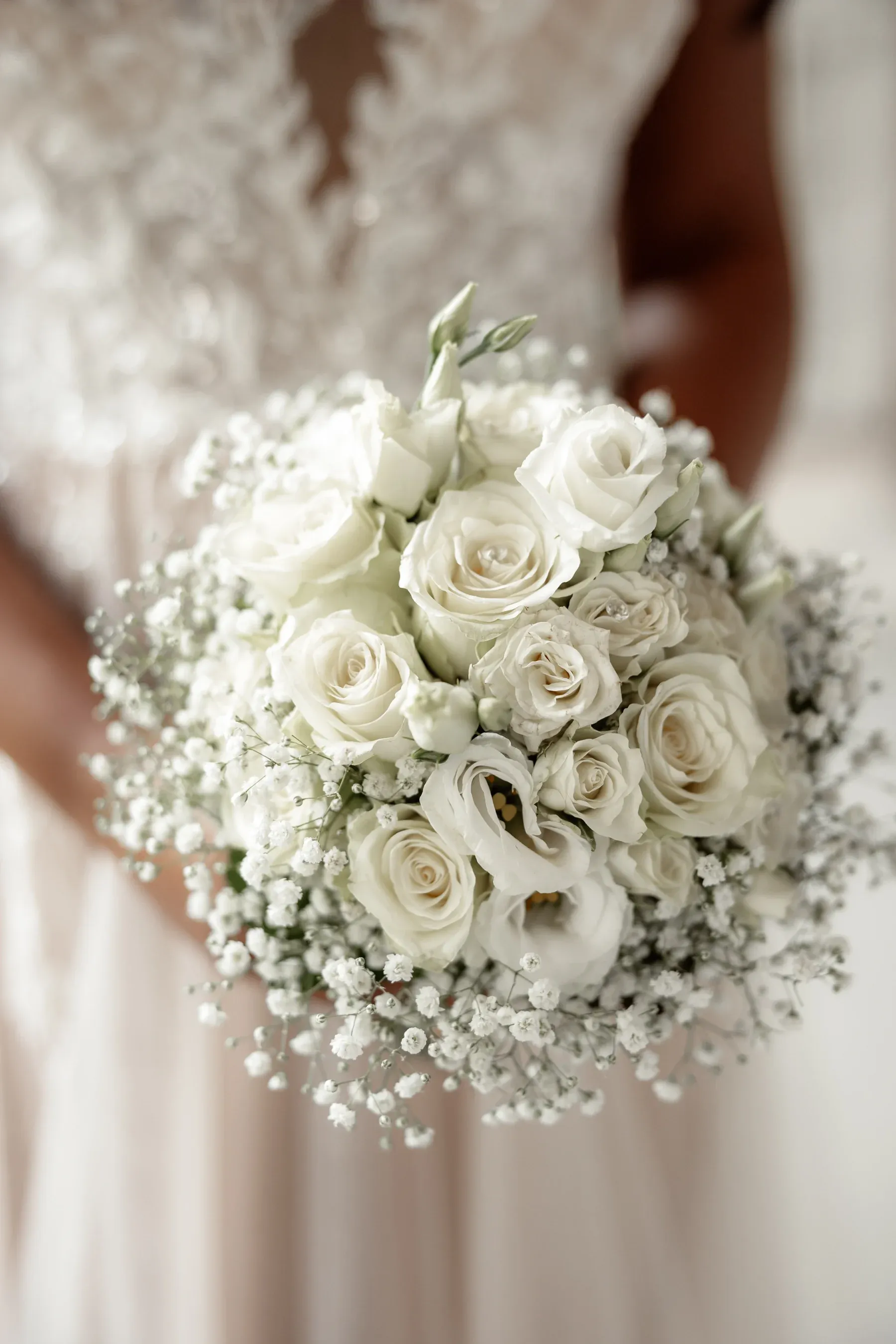 Braut mit einem Strauß aus weißen Rosen und Schleierkraut